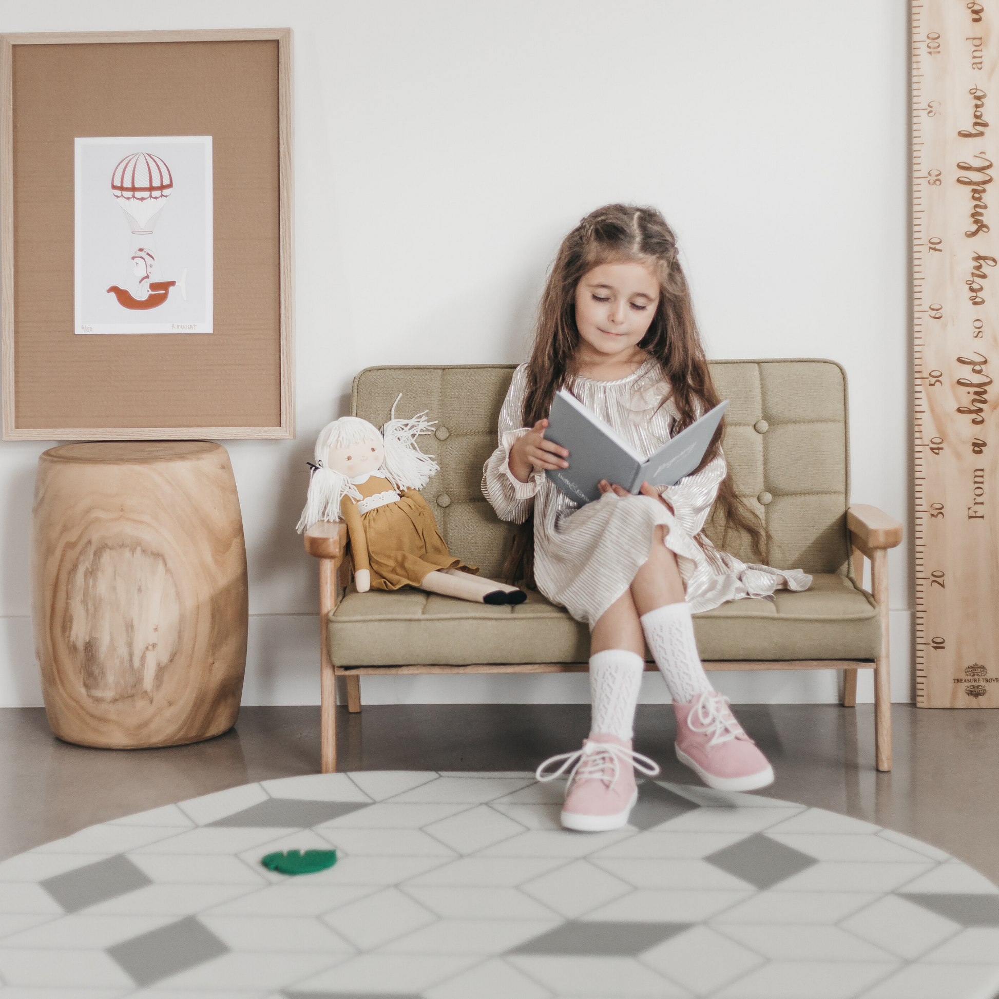 Girl sitting reading book with pink leather shoes on
