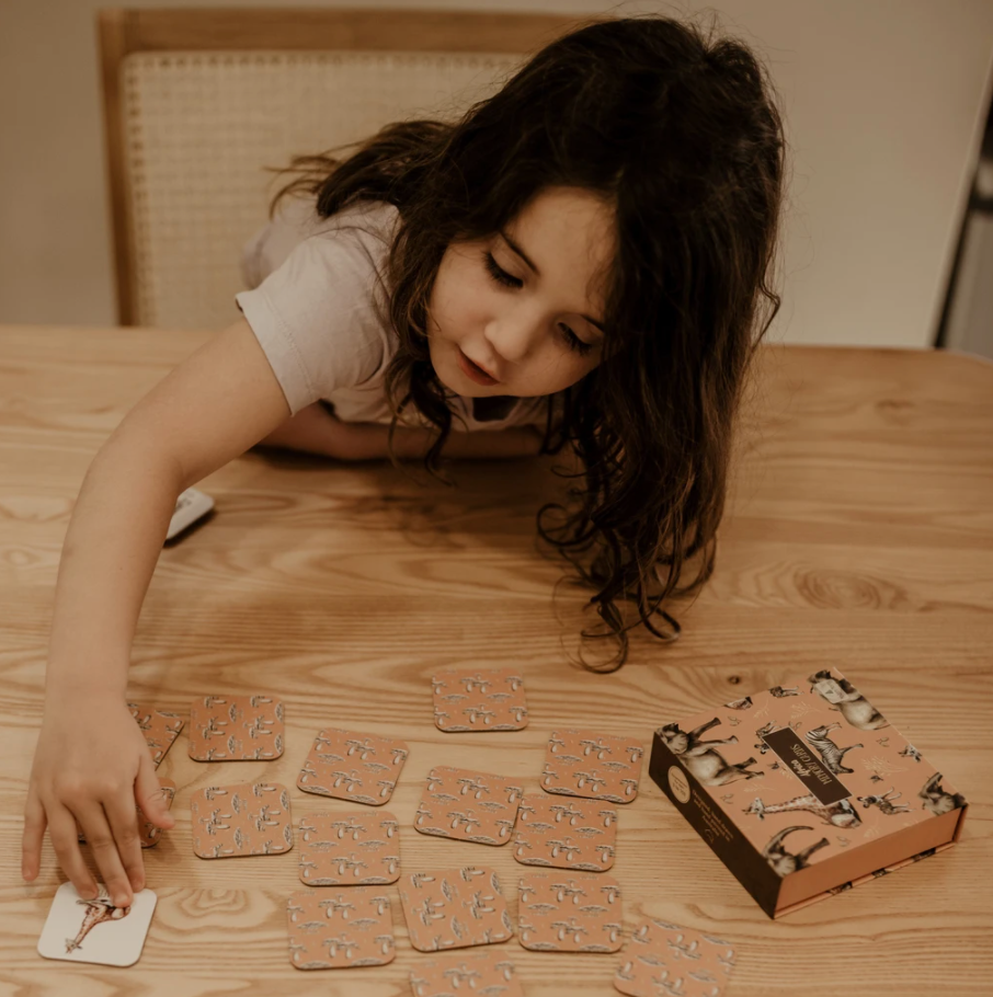 Girl flipping over card of an African themed memory game.